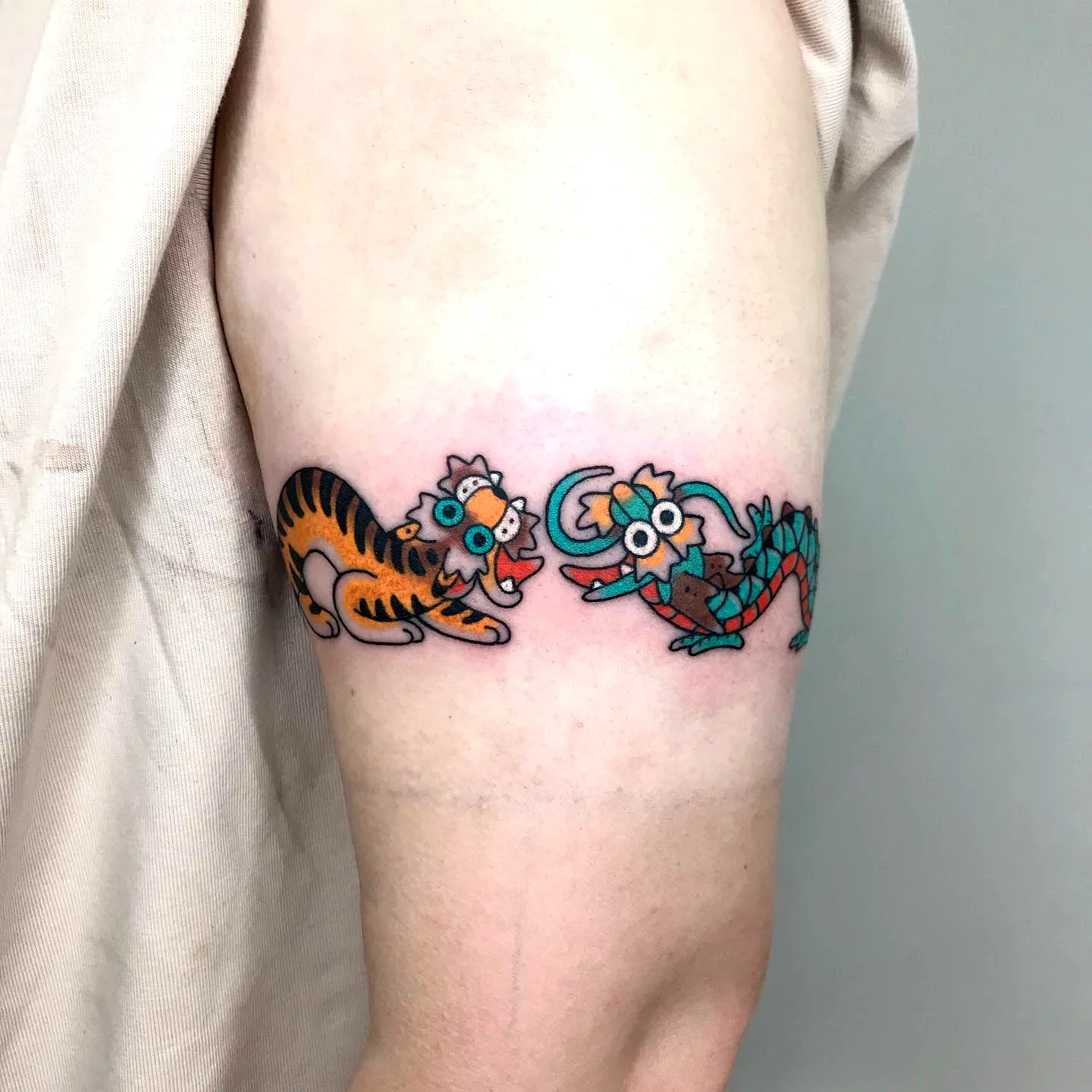 Colorful animated tiger and scorpion upper arm tattoo