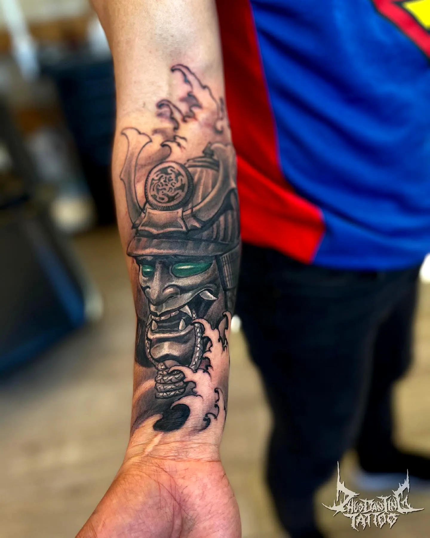 Detailed Samurai Mask Forearm Tattoo with Flowing Waves