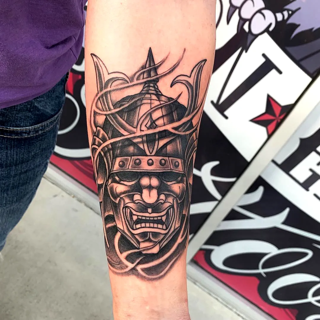 Intricate Samurai Mask Forearm Tattoo in Black and Gray Ink