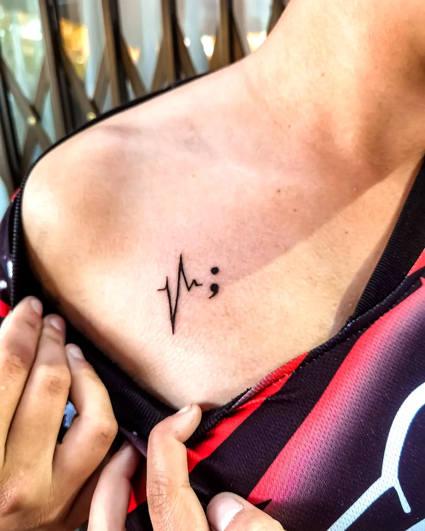 Minimalist heartbeat semicolon chest tattoo