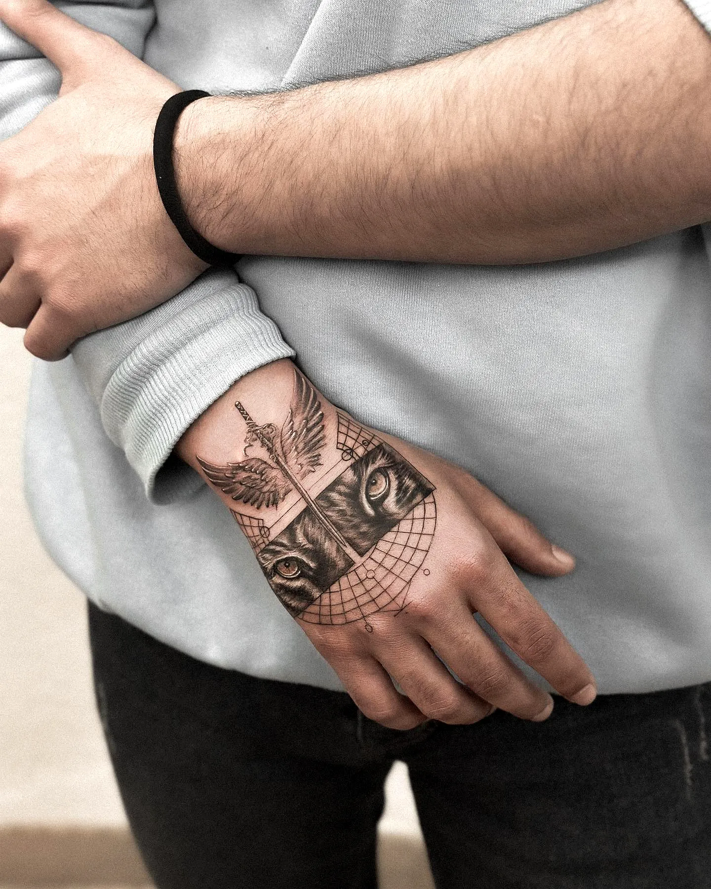 Tiger eye realistic sword and wings hand tattoo