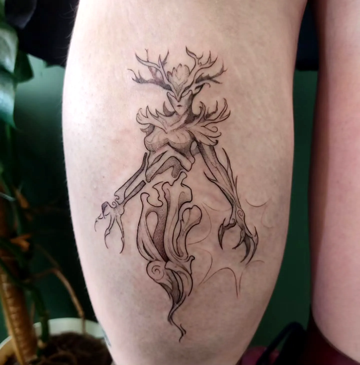 Antlered humanoid leg tattoo