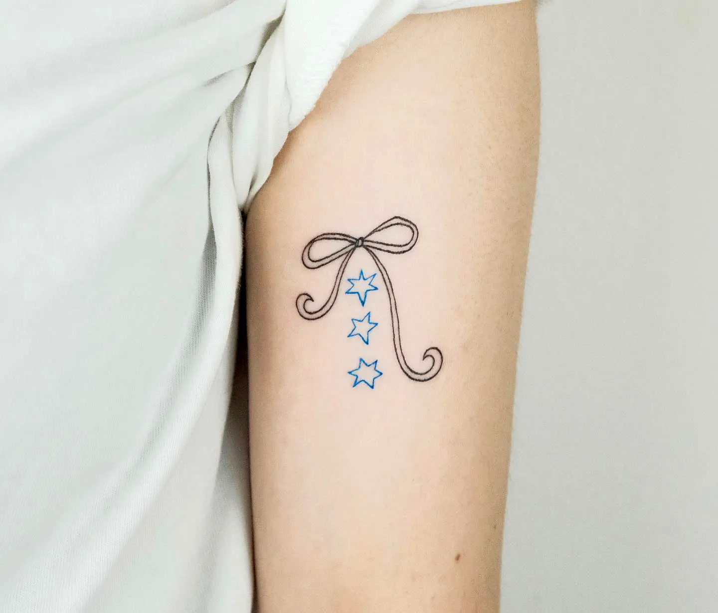 Bow and Blue Stars Inner Arm Tattoo