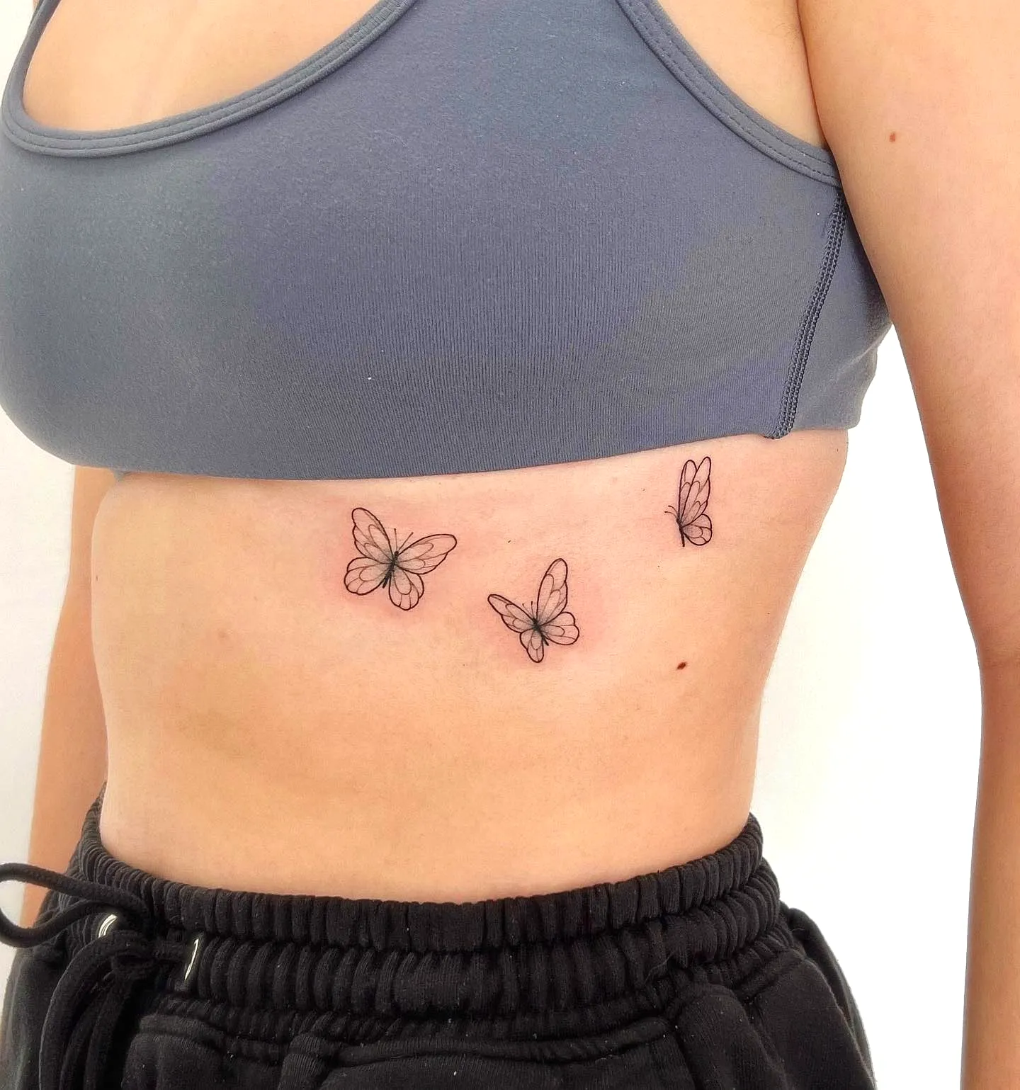 Butterflies Rib Tattoo - Minimalist Black Design