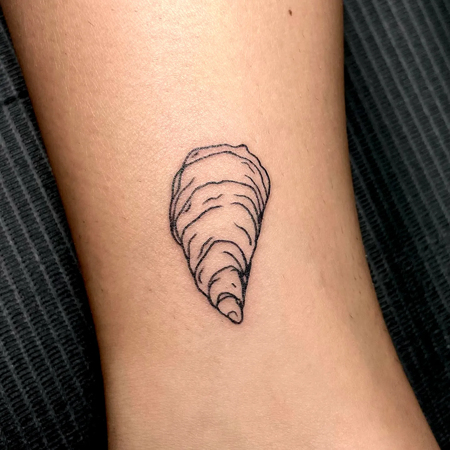 Conch Ankle Tattoo in Minimalist Style