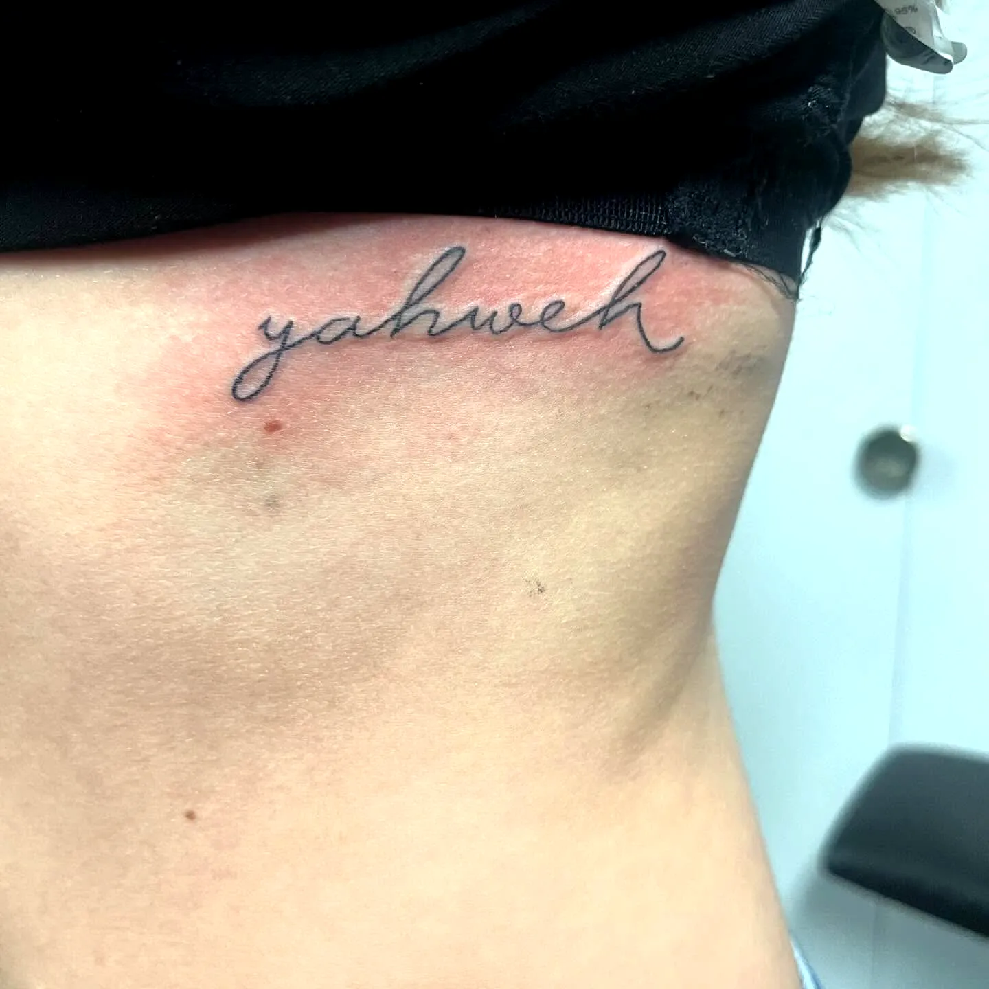 Cursive Yahweh Side Tattoo in Black Ink