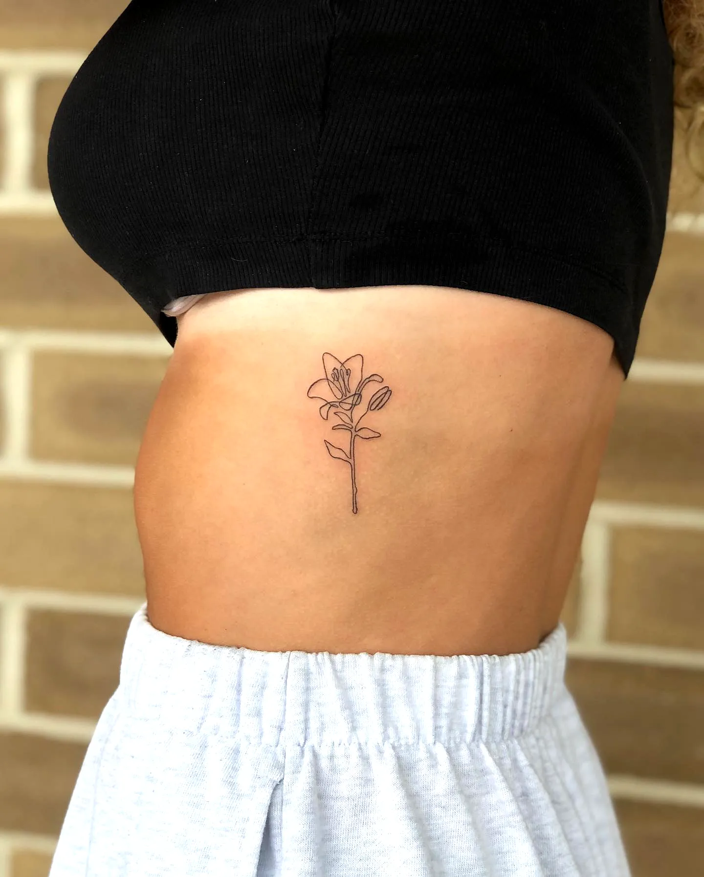 Dainty Flower Rib Tattoo in Black Ink