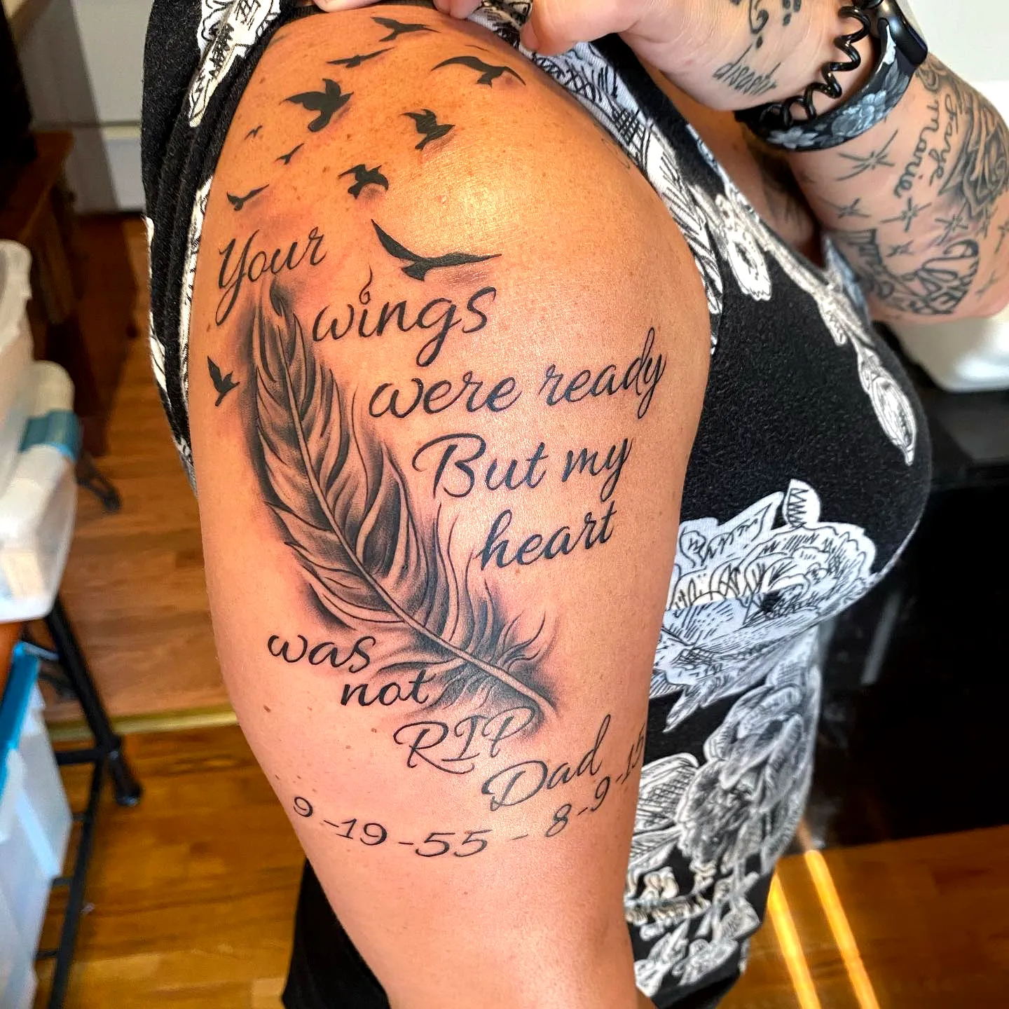Feather Upper Arm Tattoo with Rip Tribute