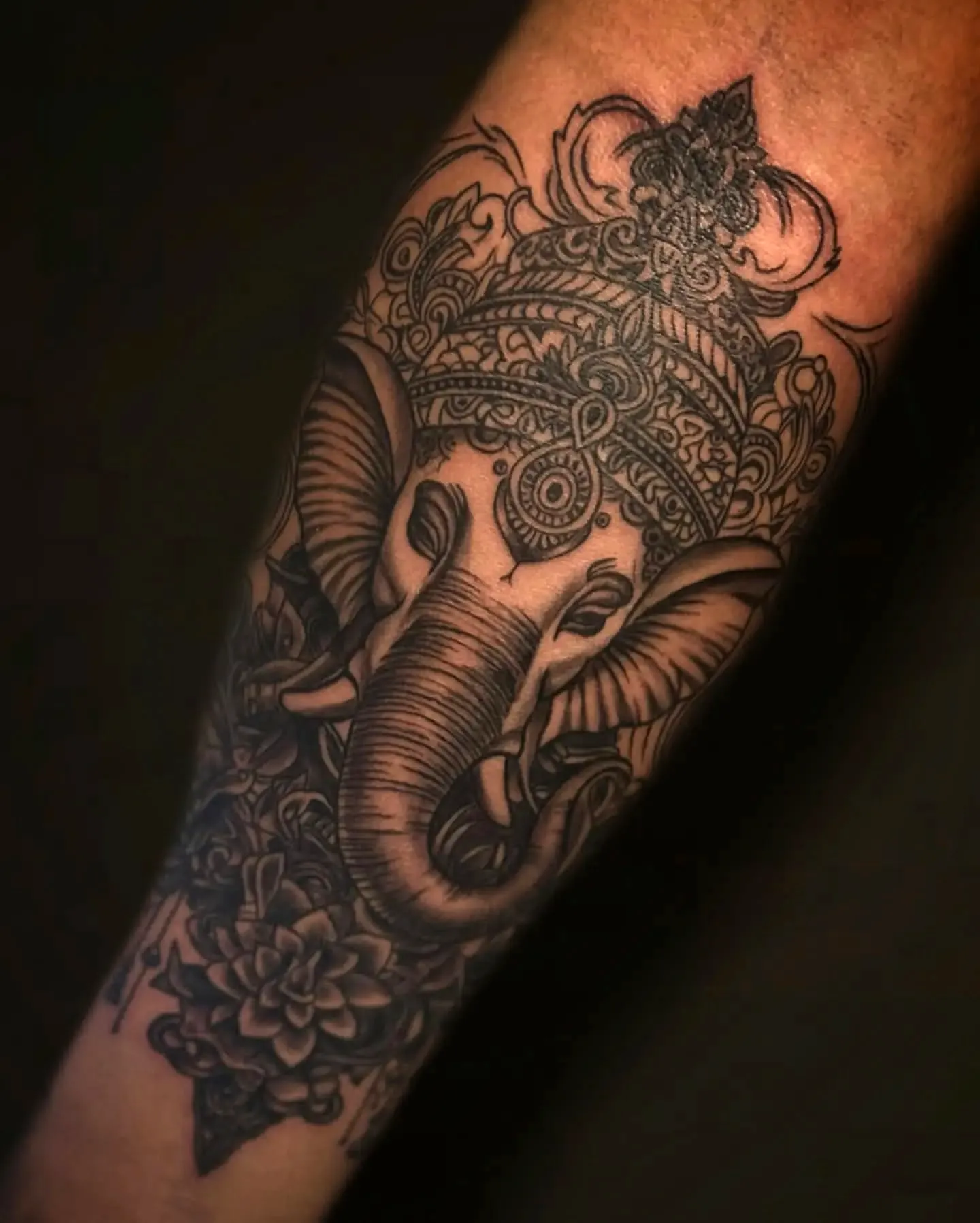 Ganesha Forearm Tattoo with Floral Elements