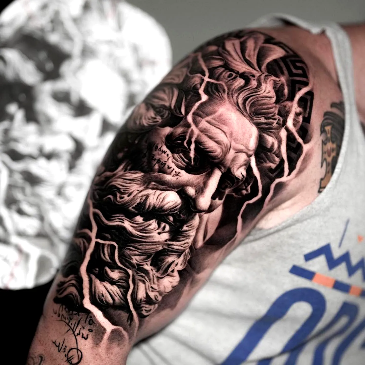 Greek God Upper Arm Tattoo in Black and Gray