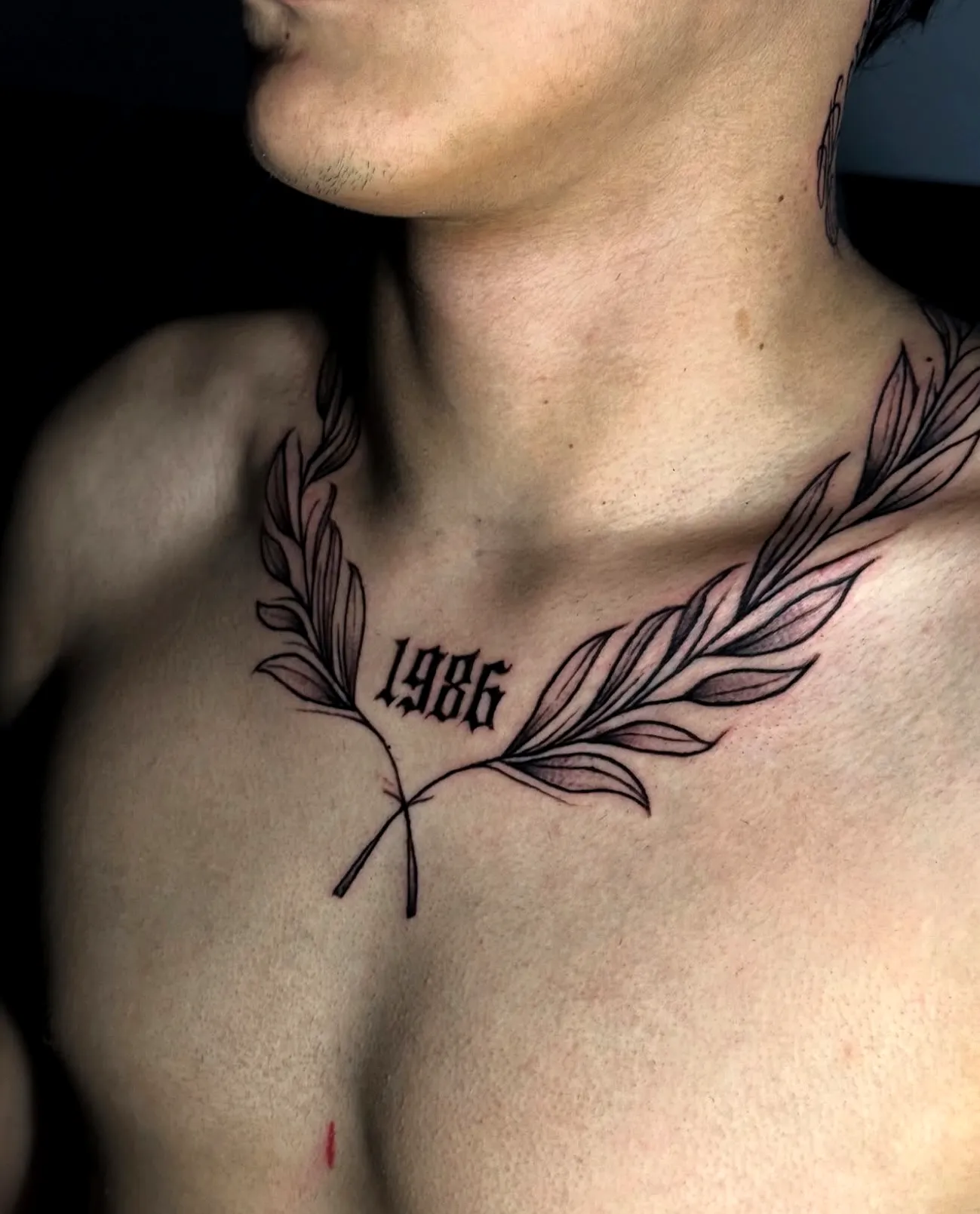 Laurel Wreath Chest Tattoo in Black Ink