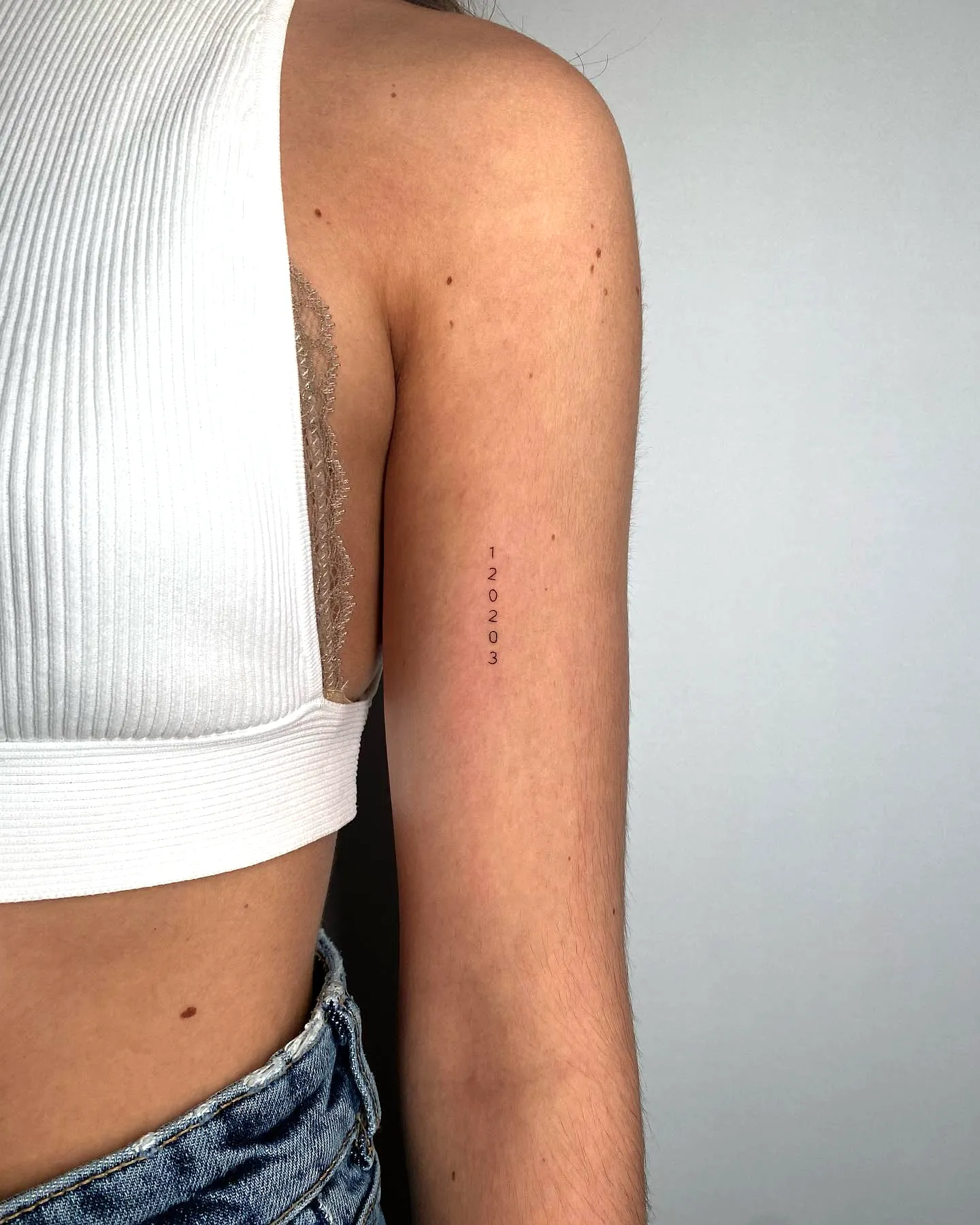 Minimalist Date Tattoo on Outer Arm