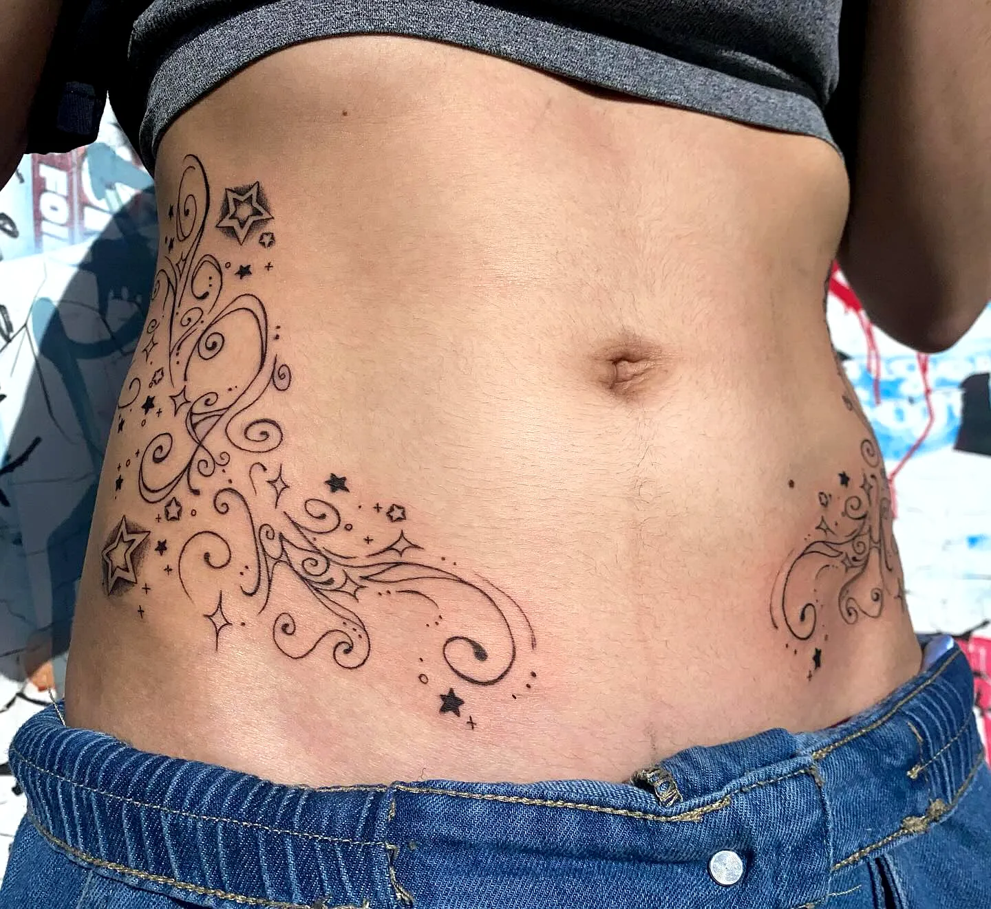 Ornate Lower Abdomen Tattoo with Stars
