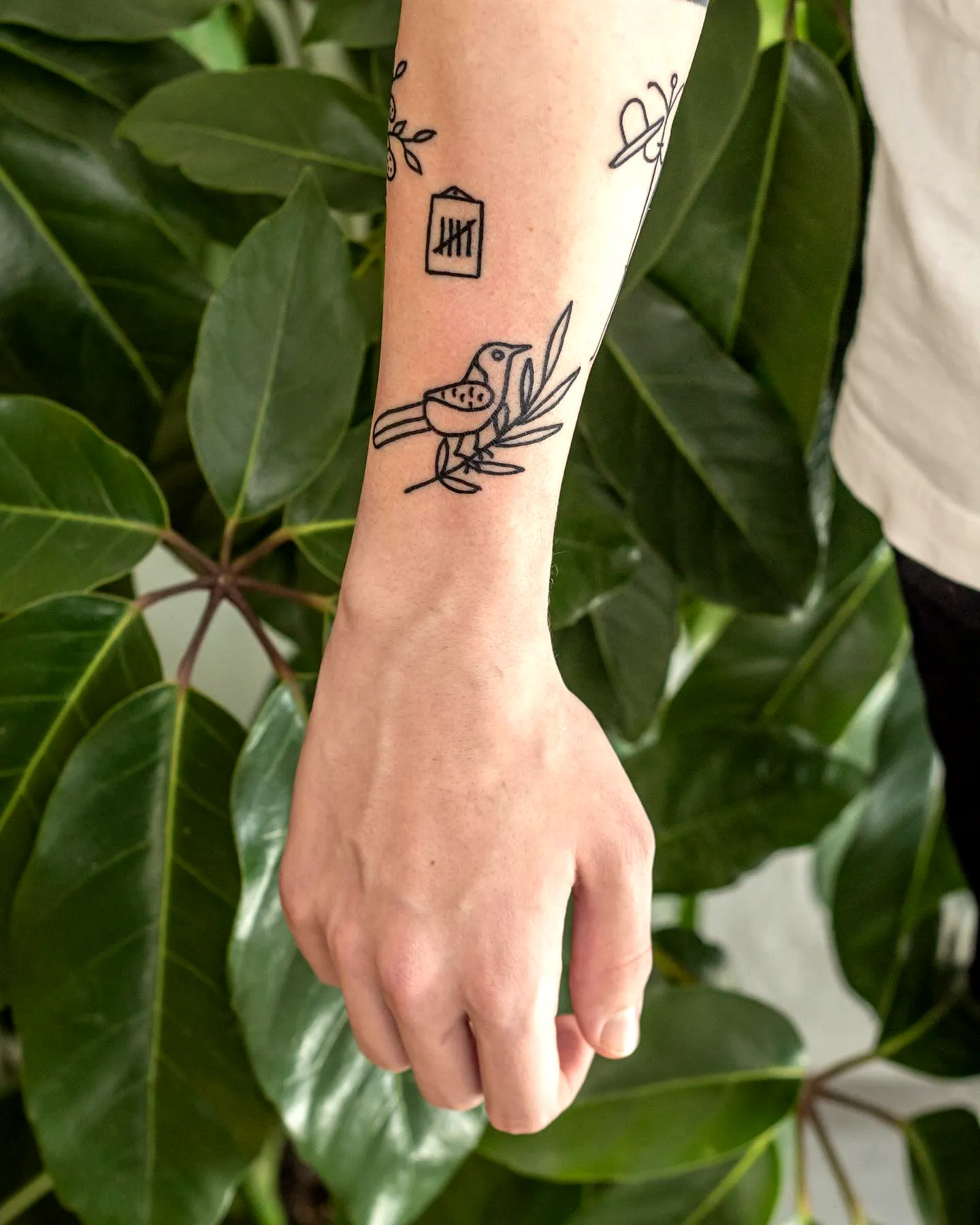 Stylized Bird Forearm Outline Tattoo