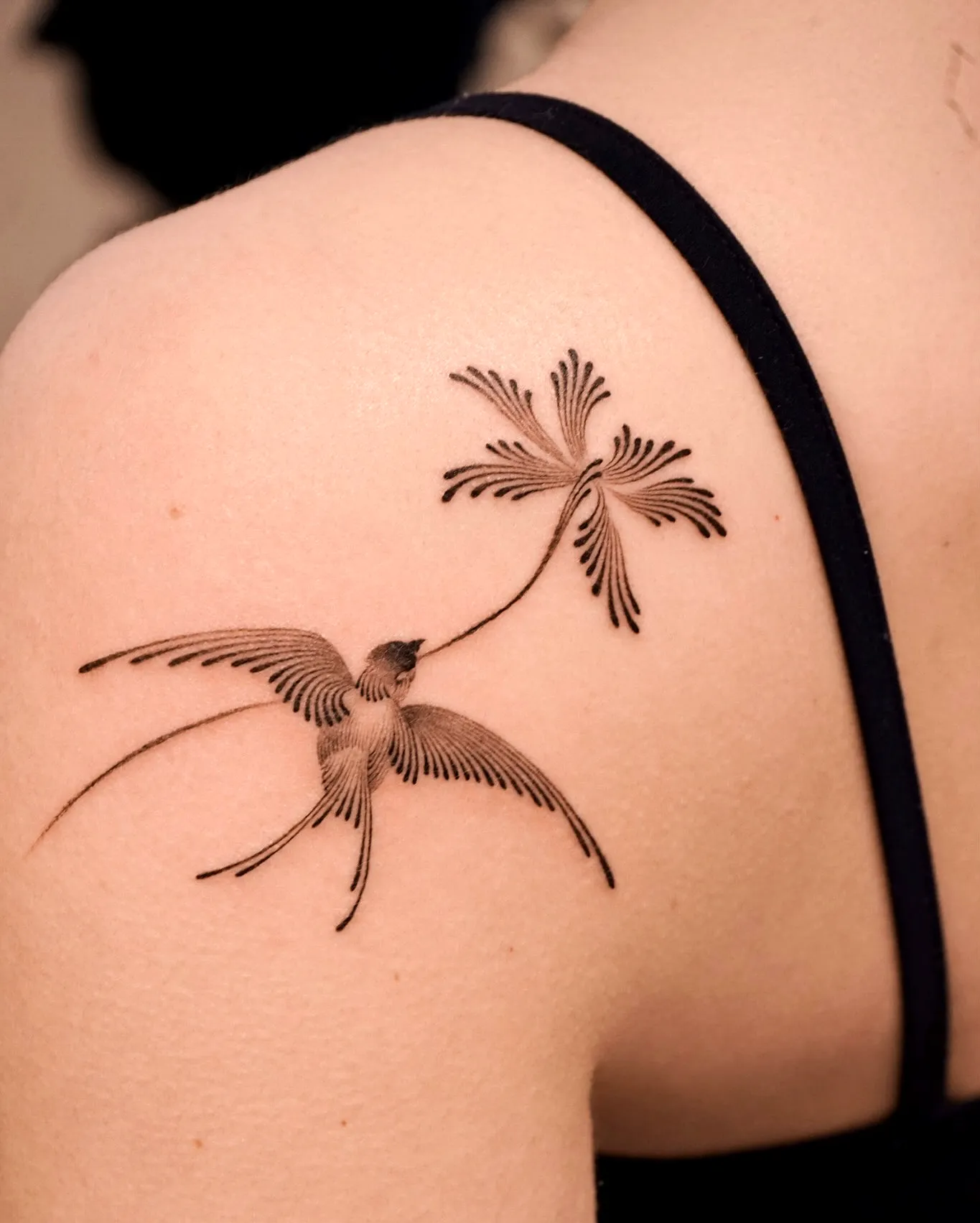 Stylized Bird Shoulder Tattoo in Black Ink