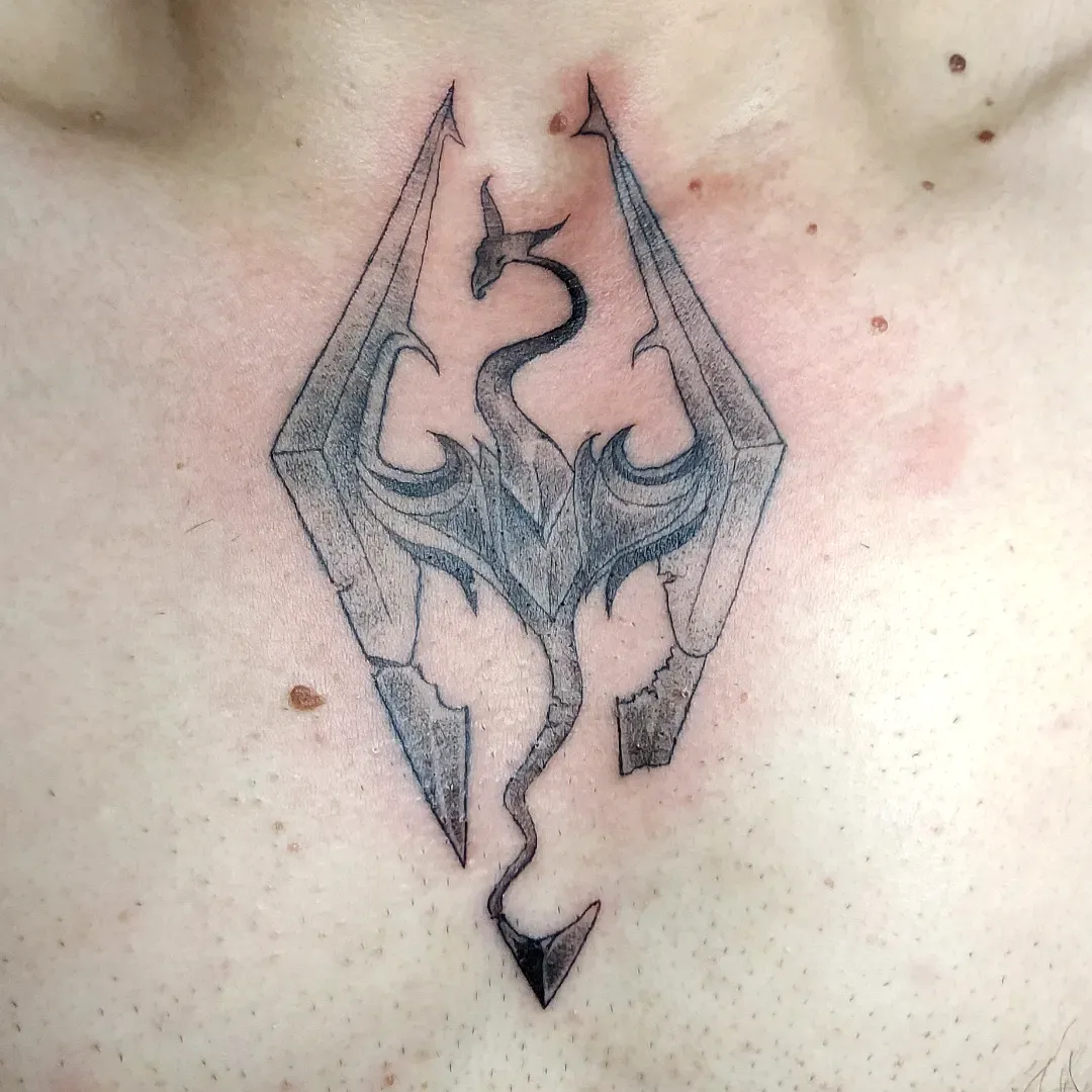 Stylized Dragon Chest Tattoo in Black Ink
