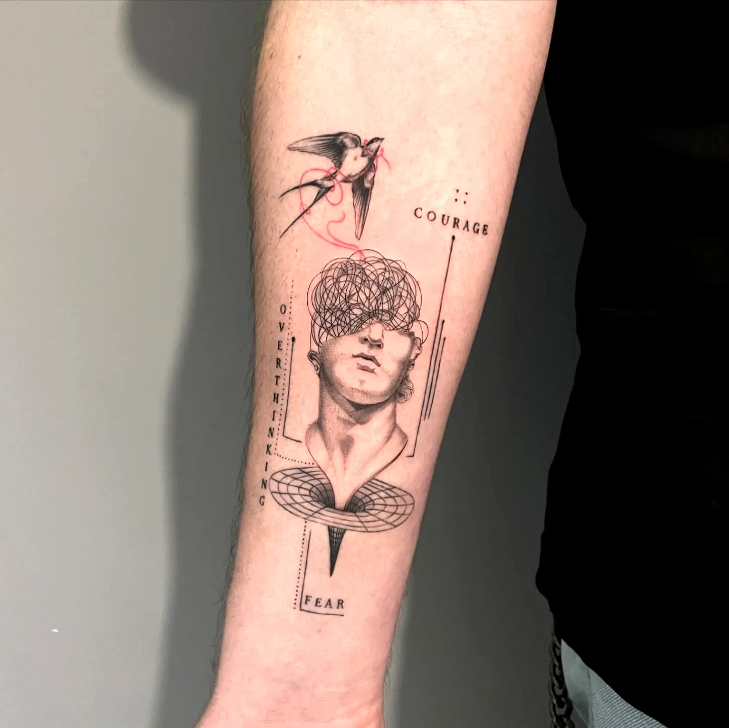 Stylized Face Forearm Tattoo in Black Ink