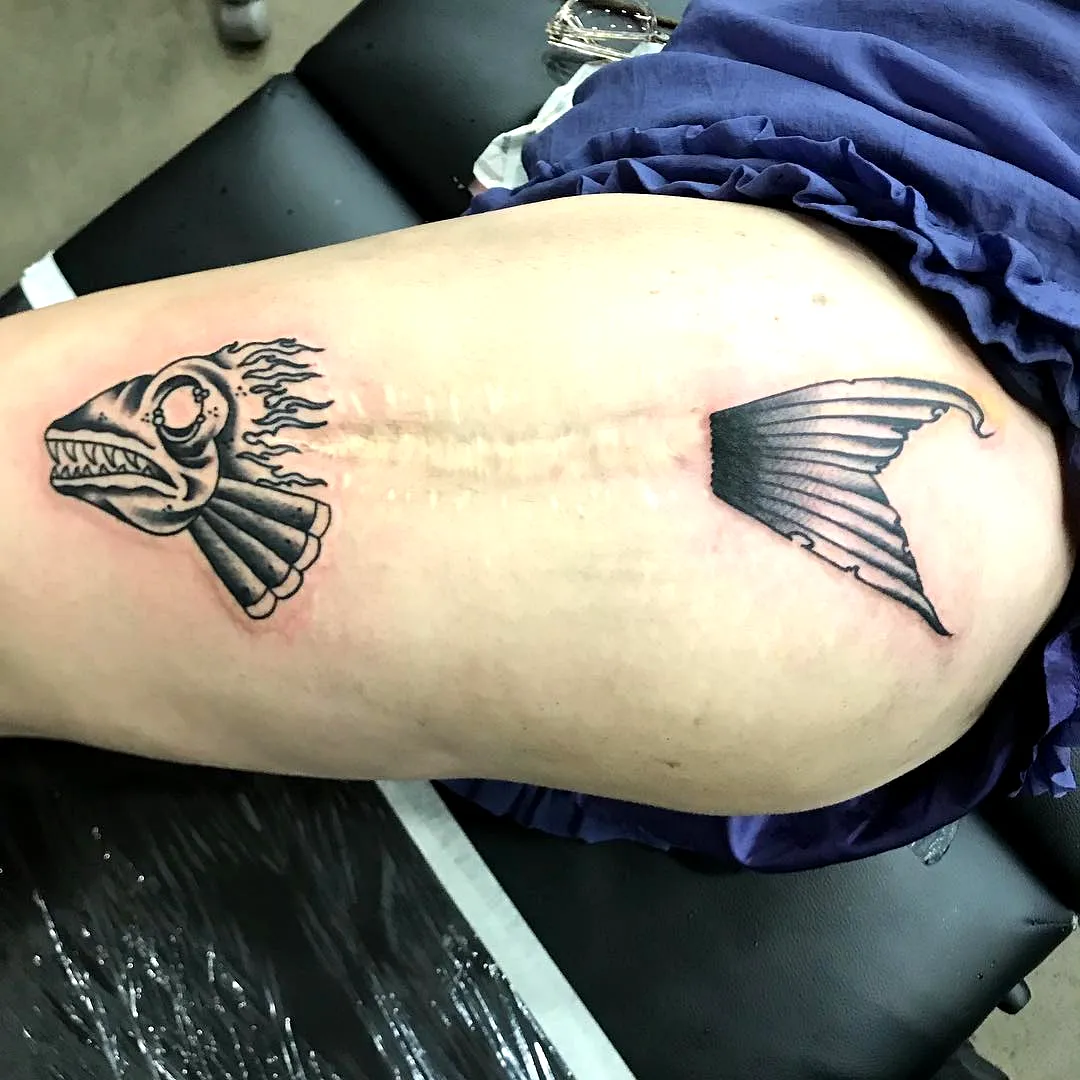 Stylized Fish Thigh Tattoo with Flames