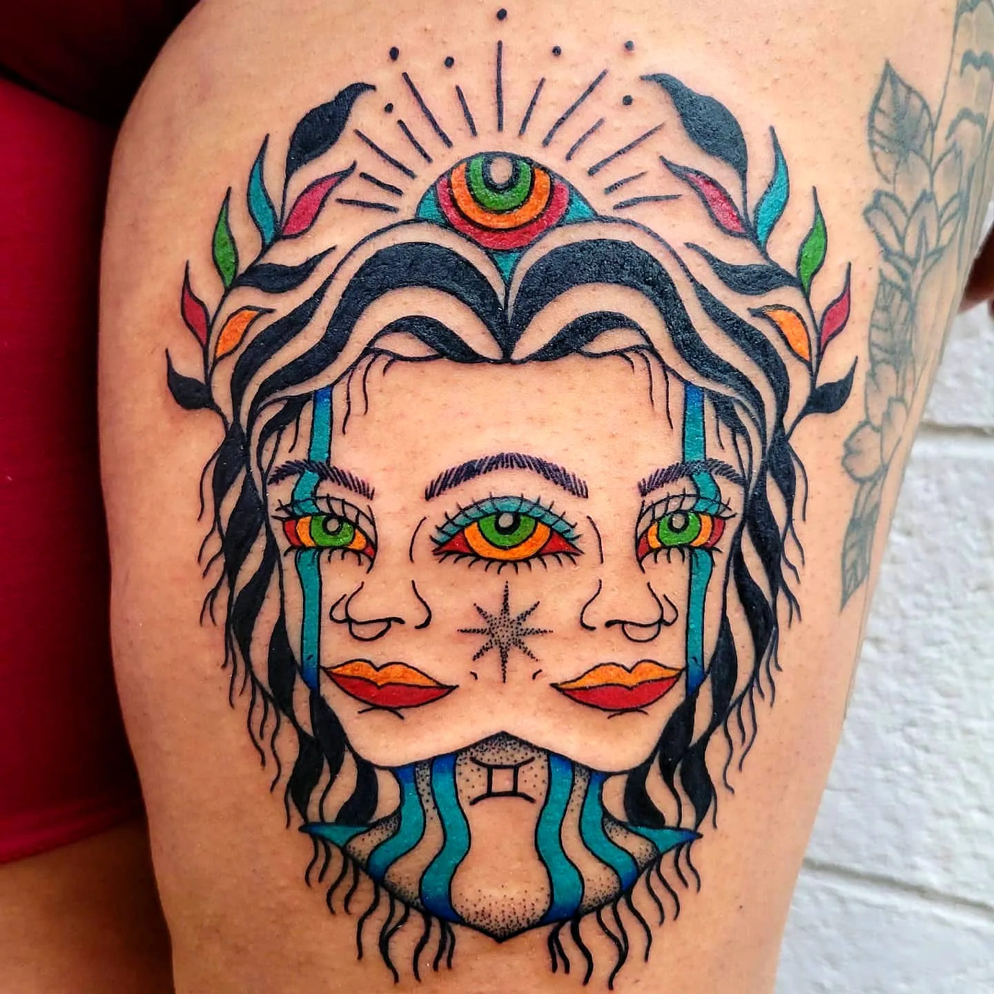 Symmetrical Face Thigh Tattoo with Foliage