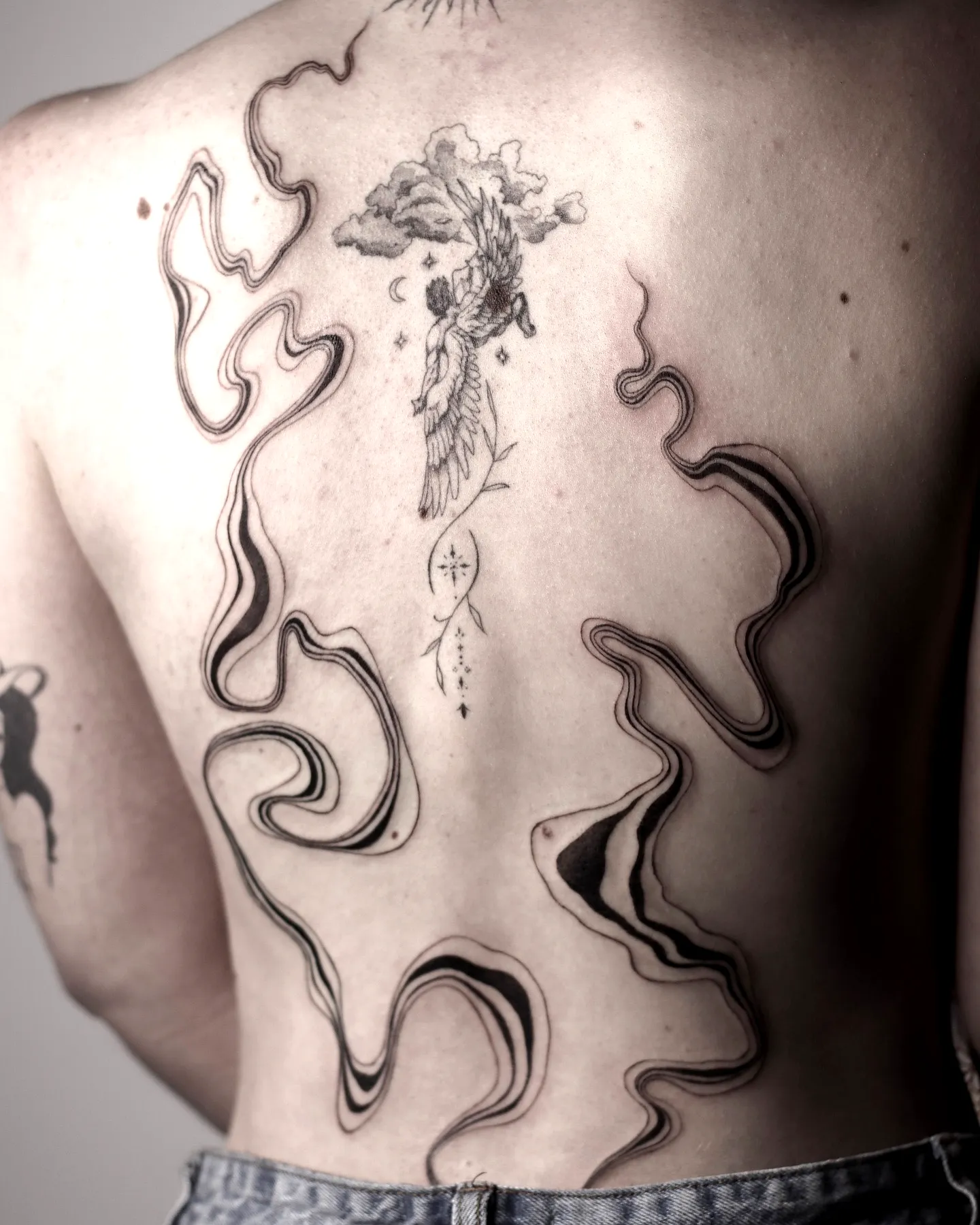 Winged Figure Spine Tattoo in Black and Gray