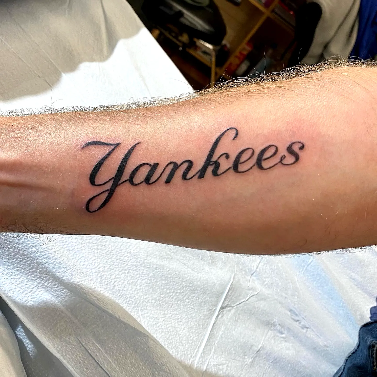 Yankees Forearm Tattoo in Cursive Black Ink